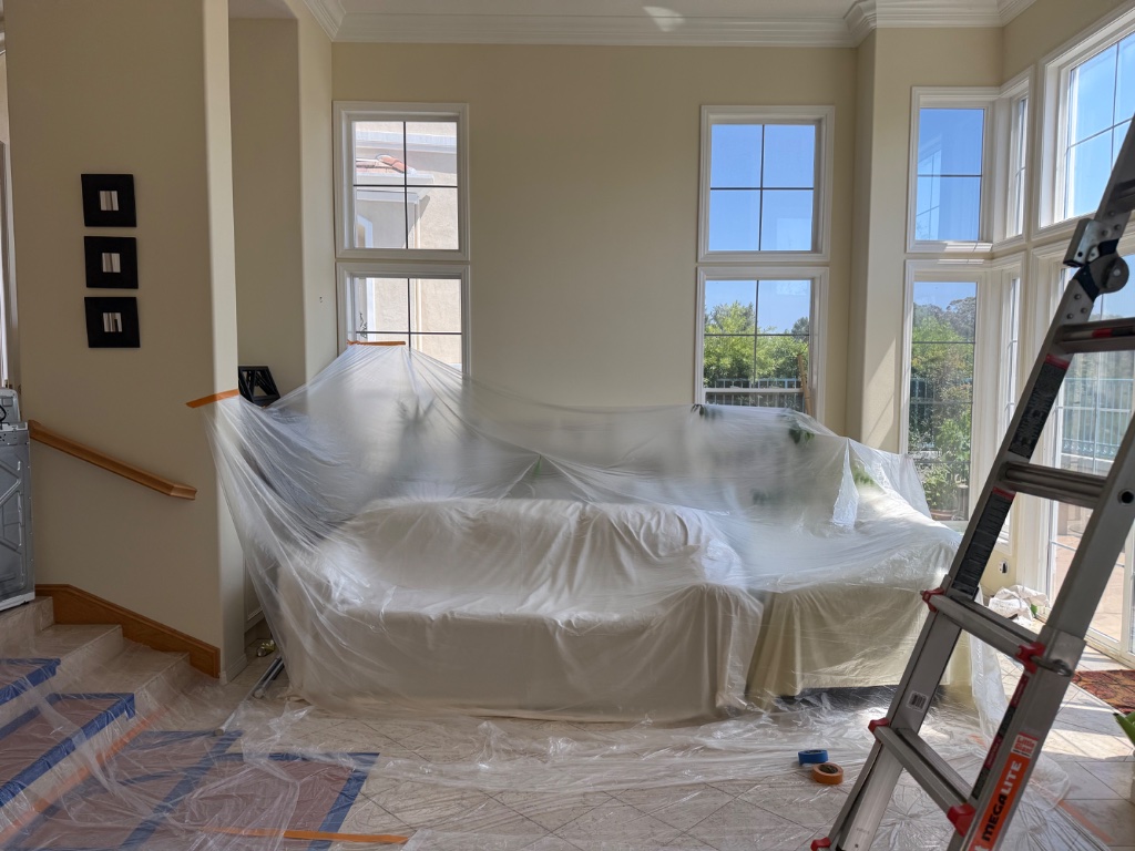 Living room furniture wrapped in plastic sheeting during repipe