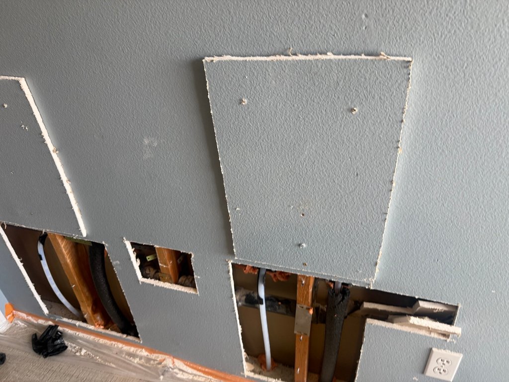 Wall openings exposing old copper and new PEX runs