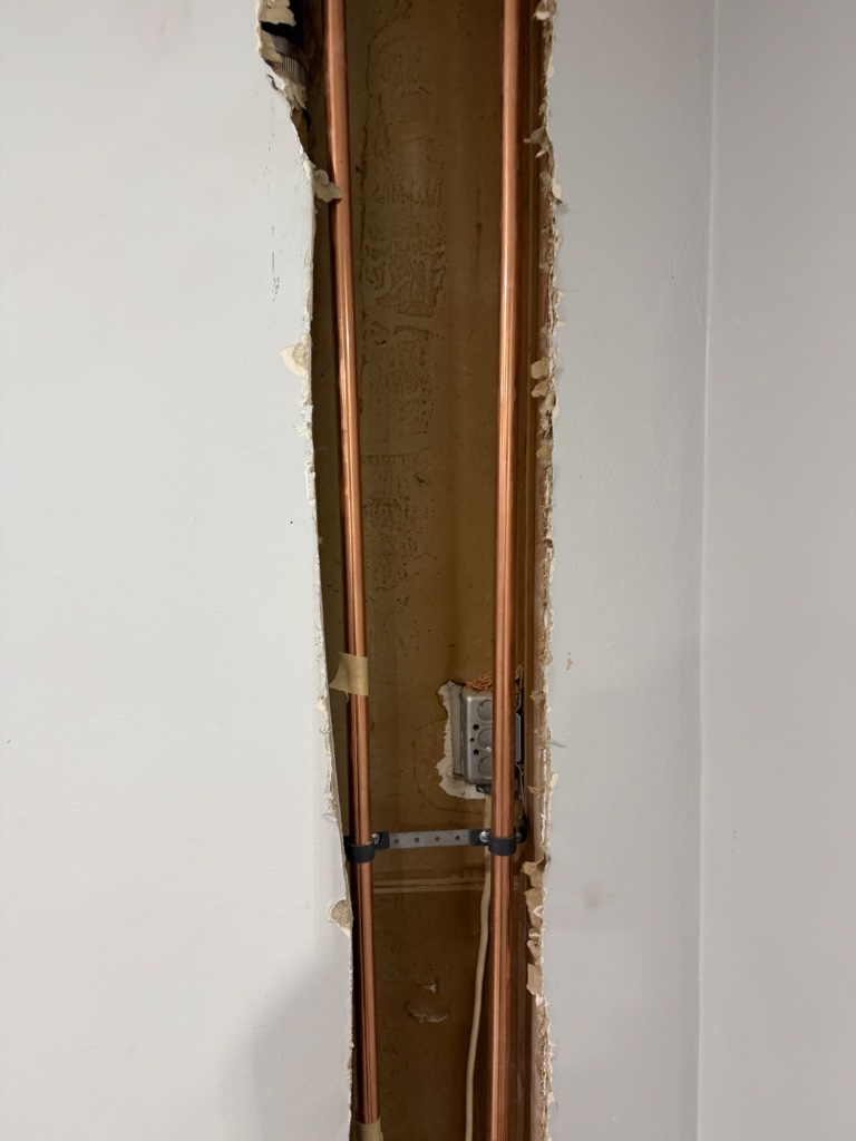 Access hole at toilet base showing new supply line stub-out installation
