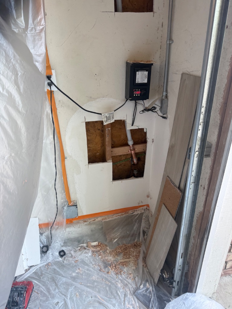 Ceiling with multiple square access holes cut for overhead pipe replacement