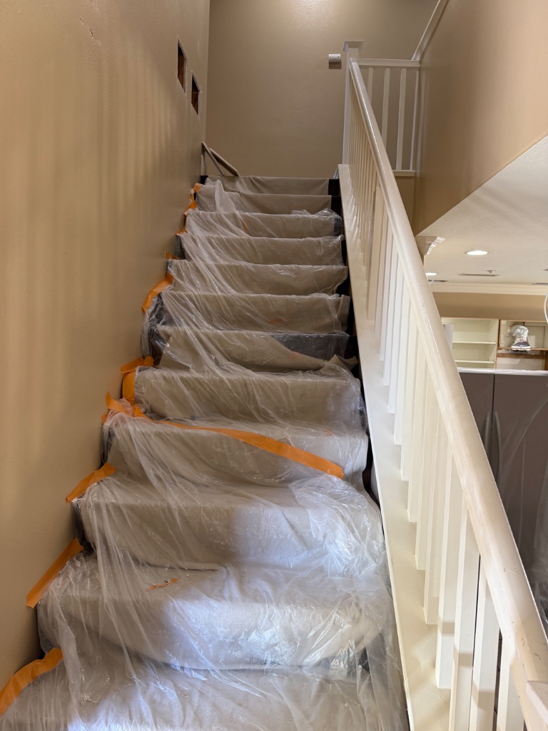 Staircase covered with plastic sheeting during whole-home repipe