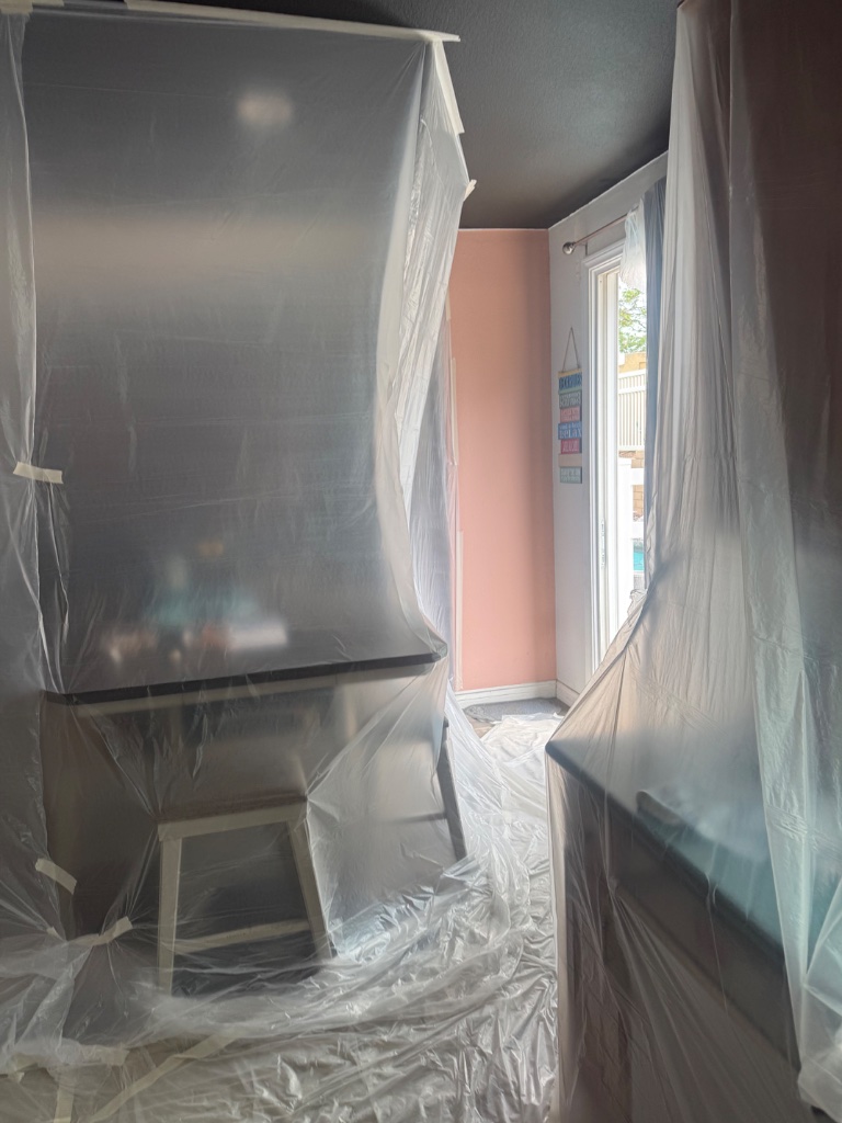 Bedroom furniture and walls protected with plastic sheeting