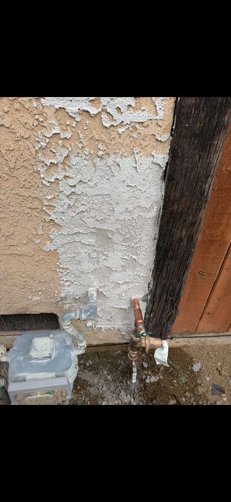 Exterior stucco patched and retextured after repipe access holes