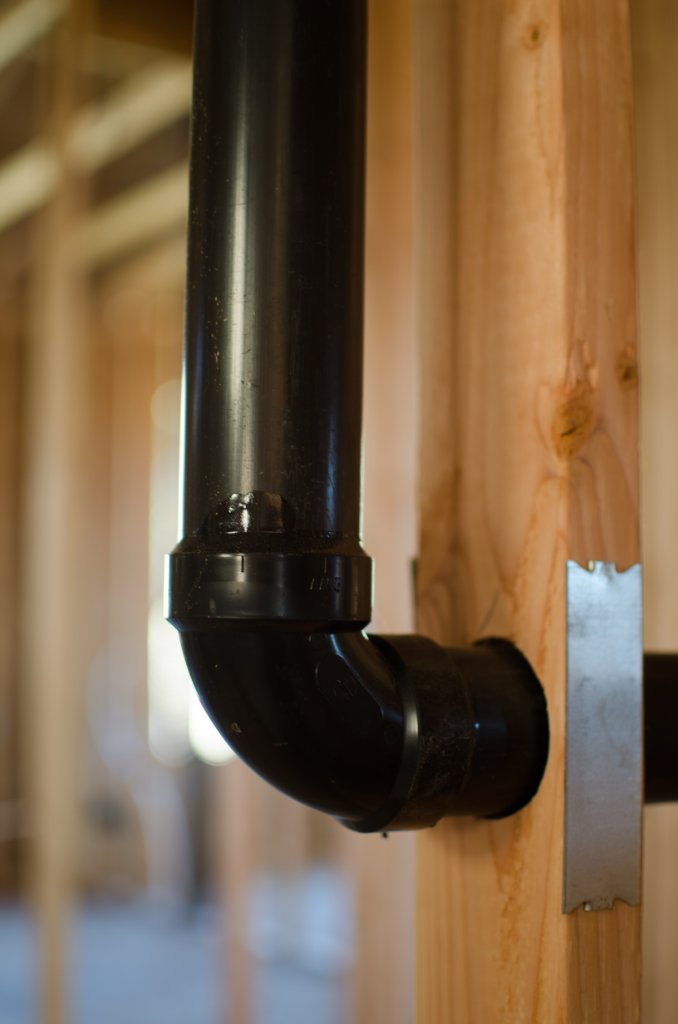 ABS elbow drain pipe fitting installed through stud