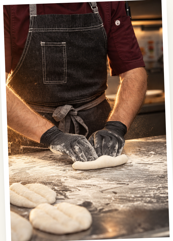 Baker shaping fresh dough in the kitchen