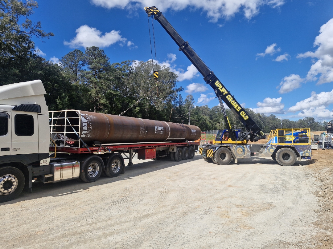 Uplift Cranes QLD mobile crane loading an ABFI Steel Group pipe onto an AFM flatbed trailer