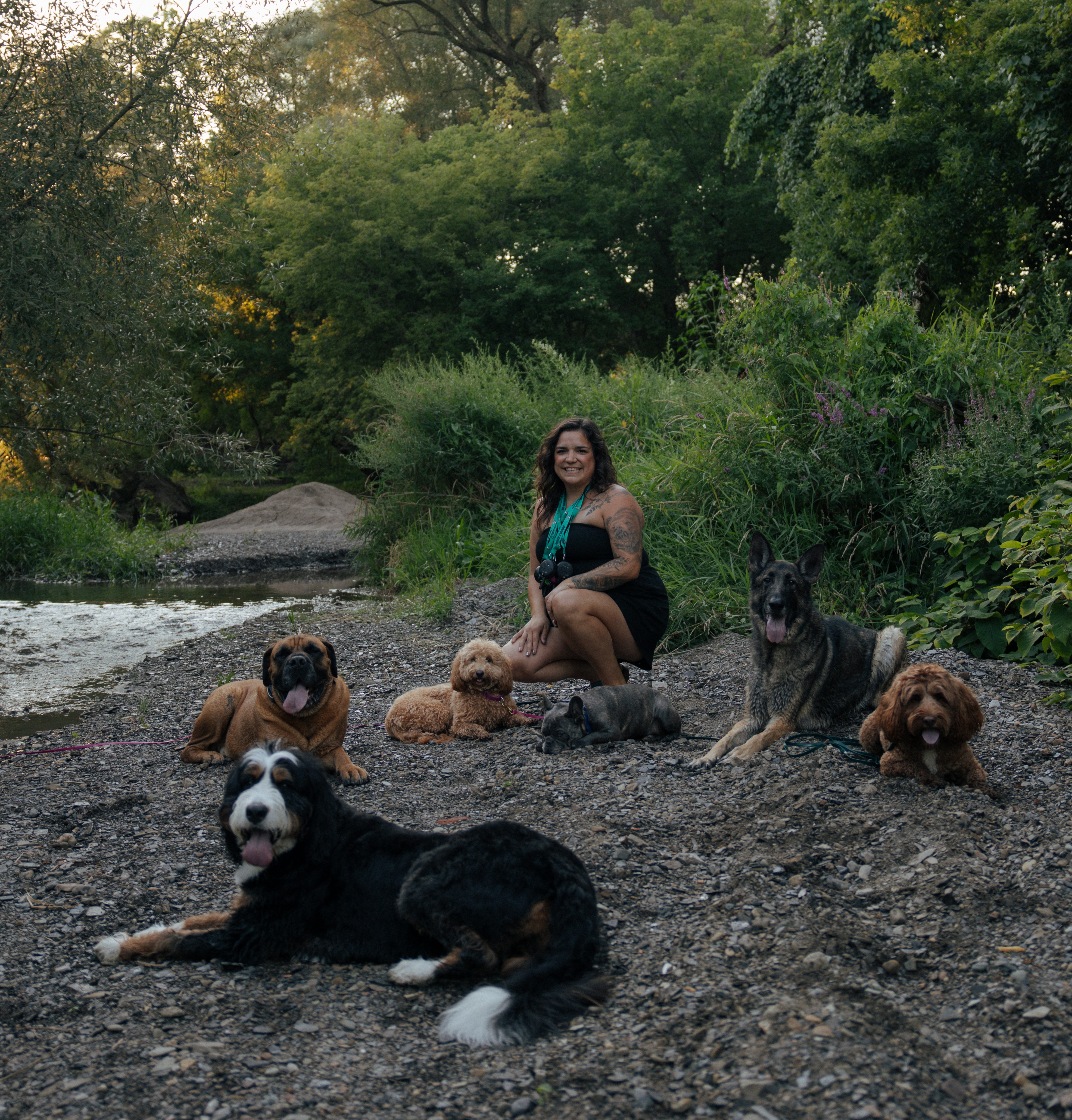 Emily surrounded by dogs on the riverbank