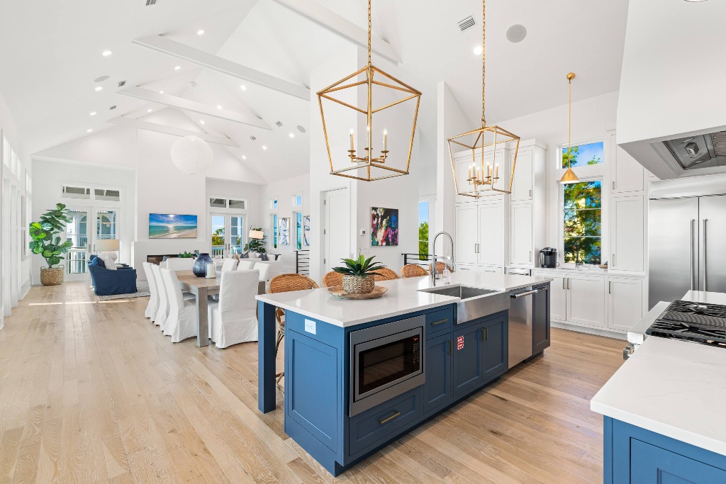 Kitchen with navy island and gold pendants