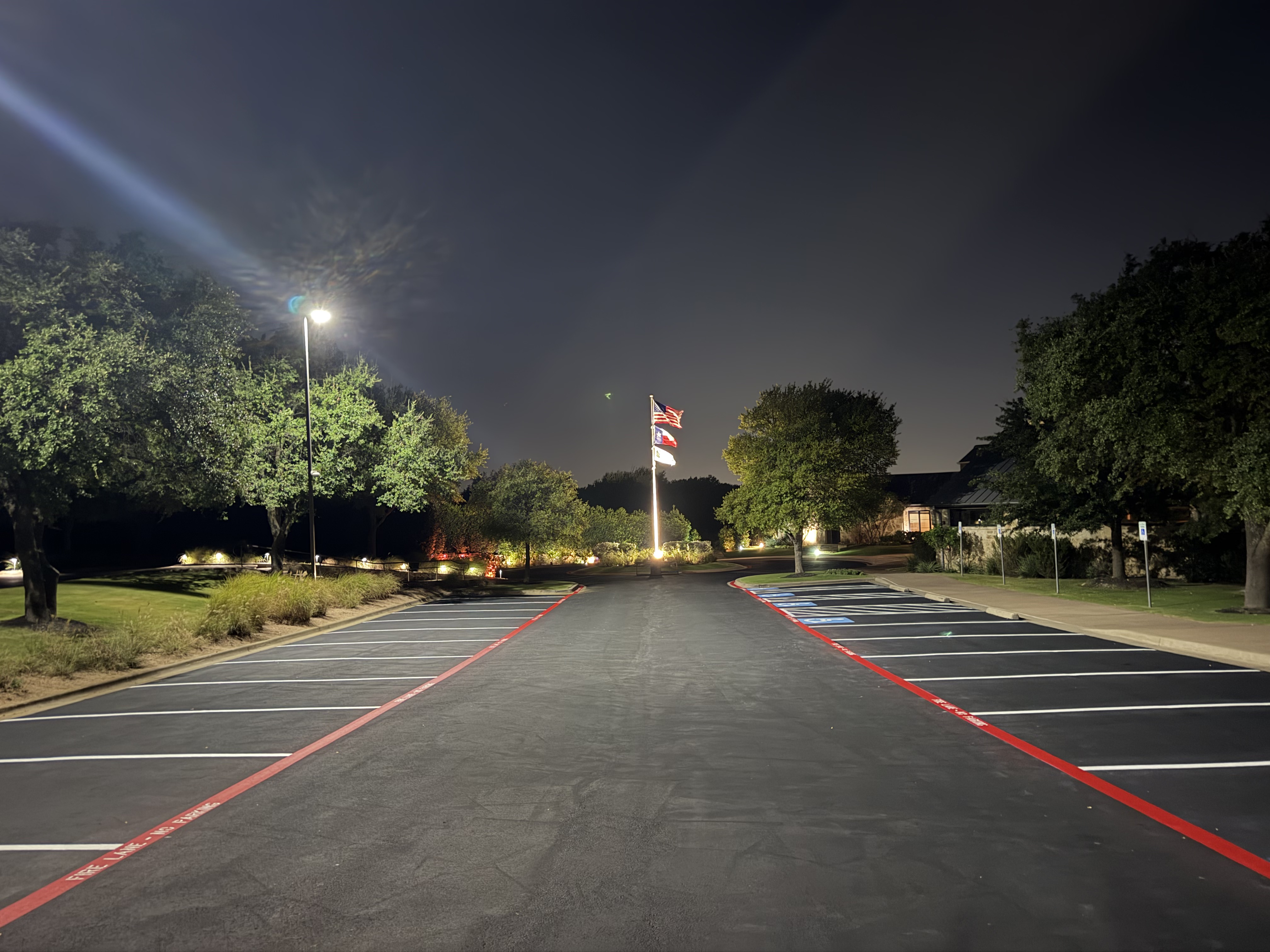 Night parking lot with flagpole and fire lane