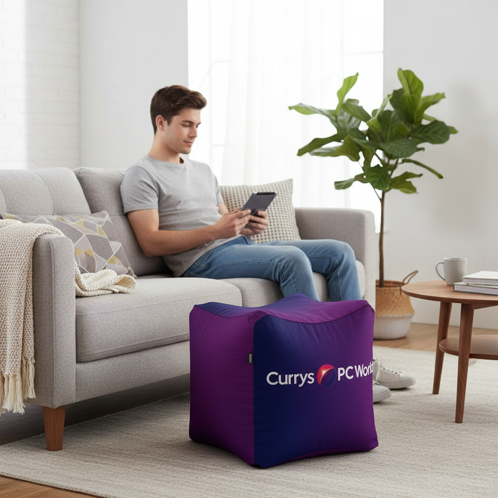 Purple cube bean bag beside sofa, perfect for home decor.