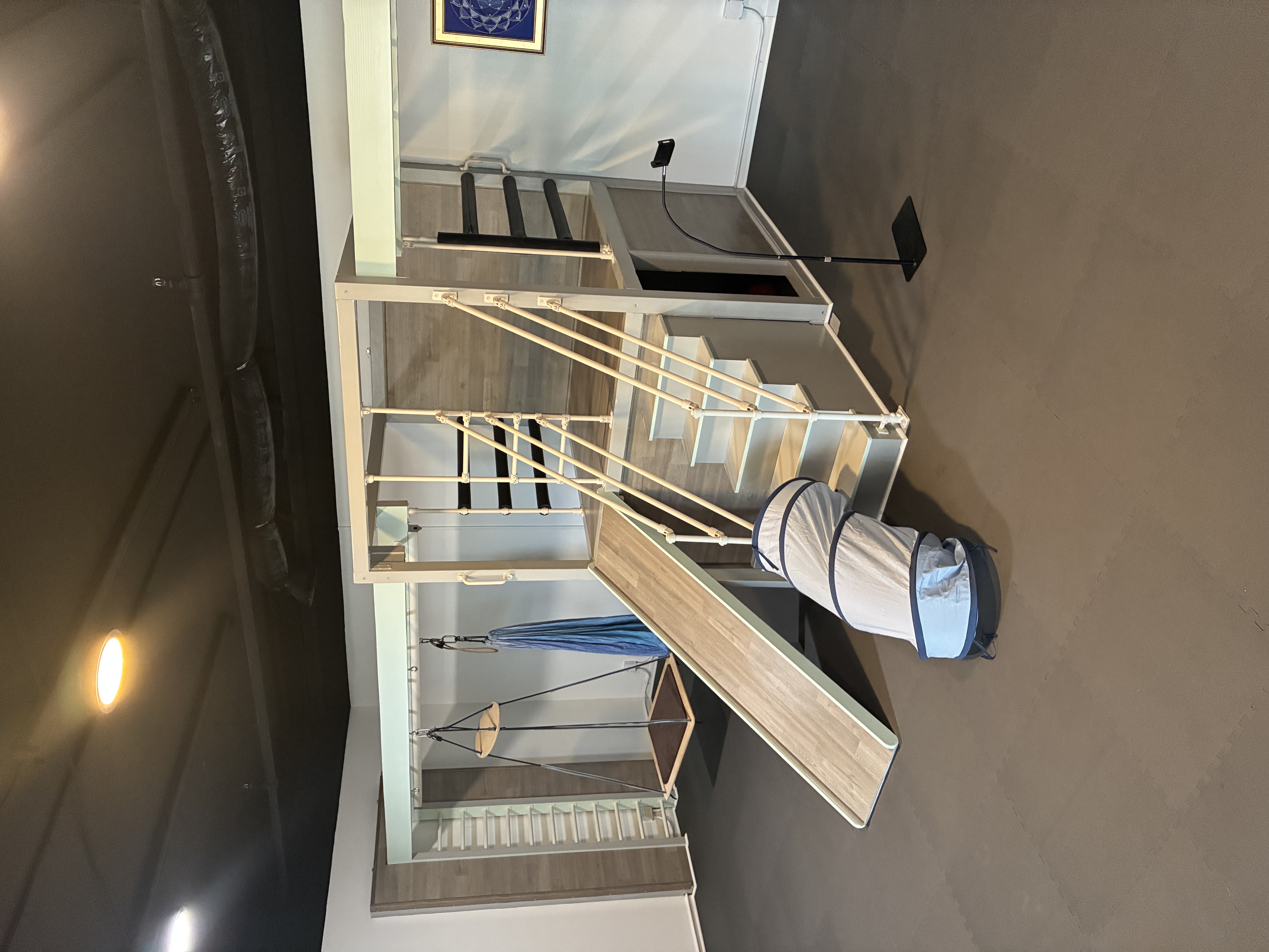 Kids play structure with slide, sensory swing, and climbing loft at Illuminate Studios