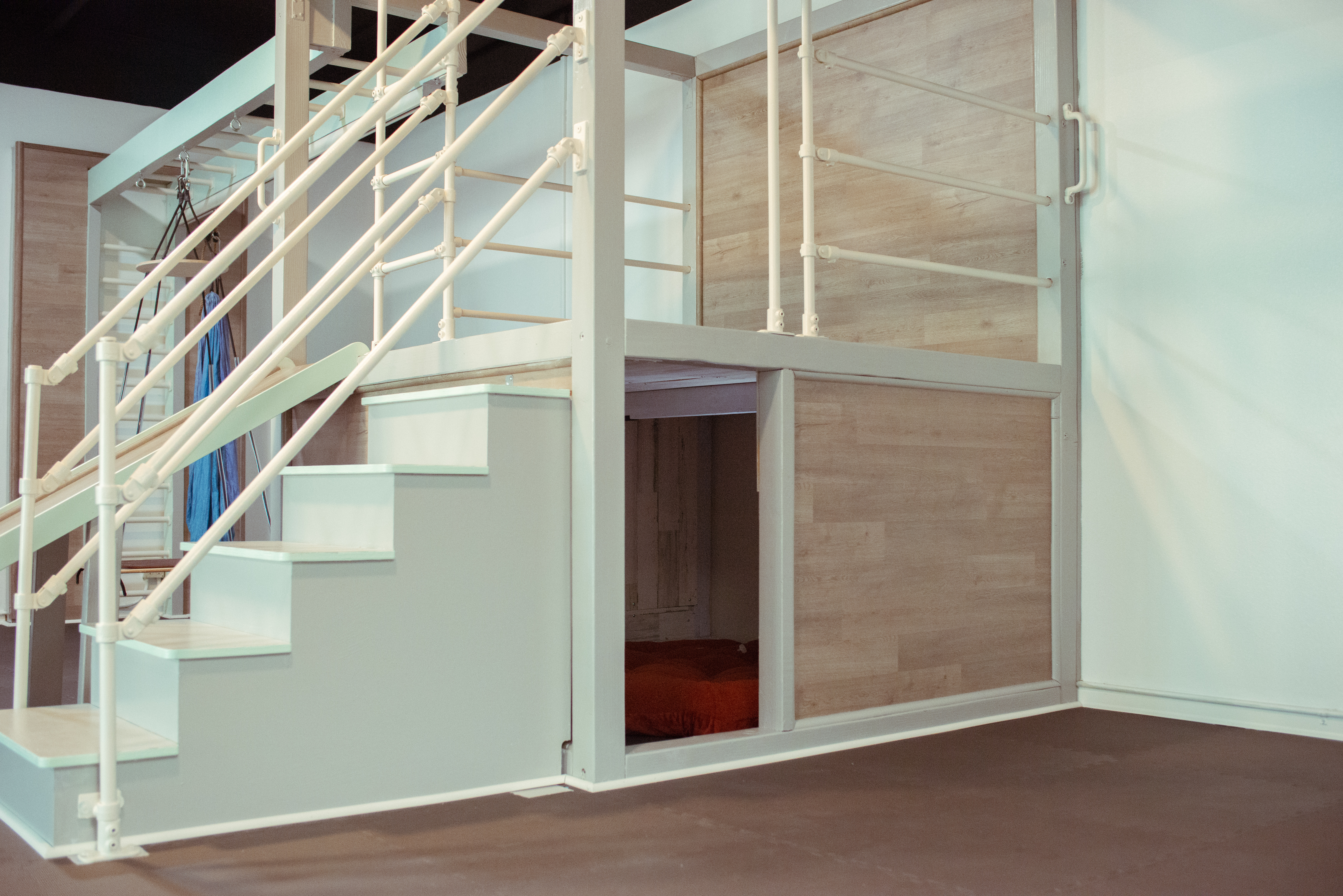 Raised wooden deck with staircase and cubby underneath