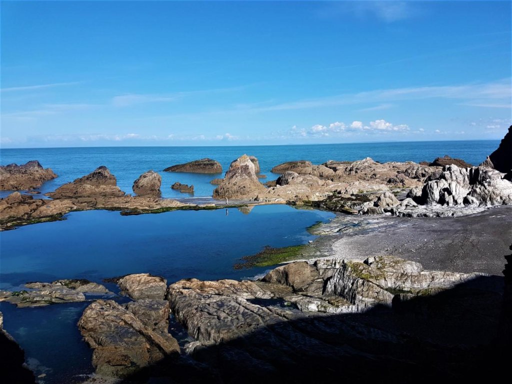 Coastal walkers resting at Tunnels Beaches, Ilfracombe — just 5 minutes from Avoncourt Lodge