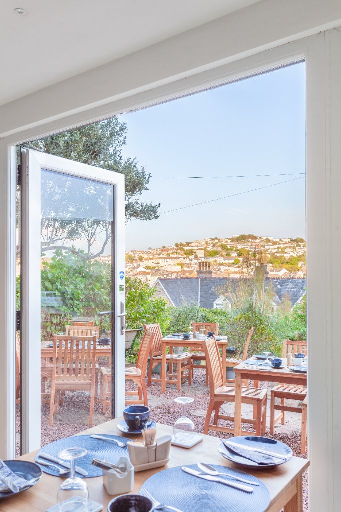View from the breakfast room through open doors to the terrace and Ilfracombe