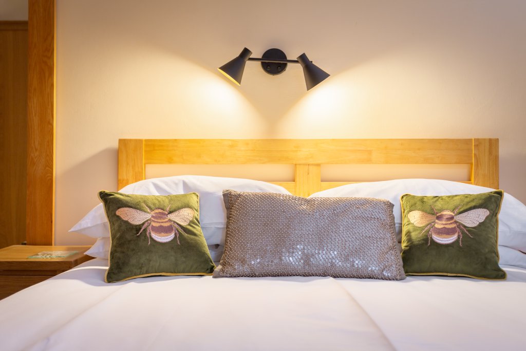 Close-up of bee cushion detailing in a double room at Avoncourt Lodge
