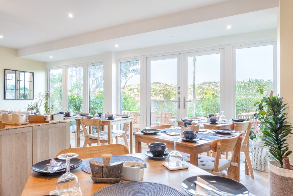 Bright breakfast dining room with garden views at Avoncourt Lodge
