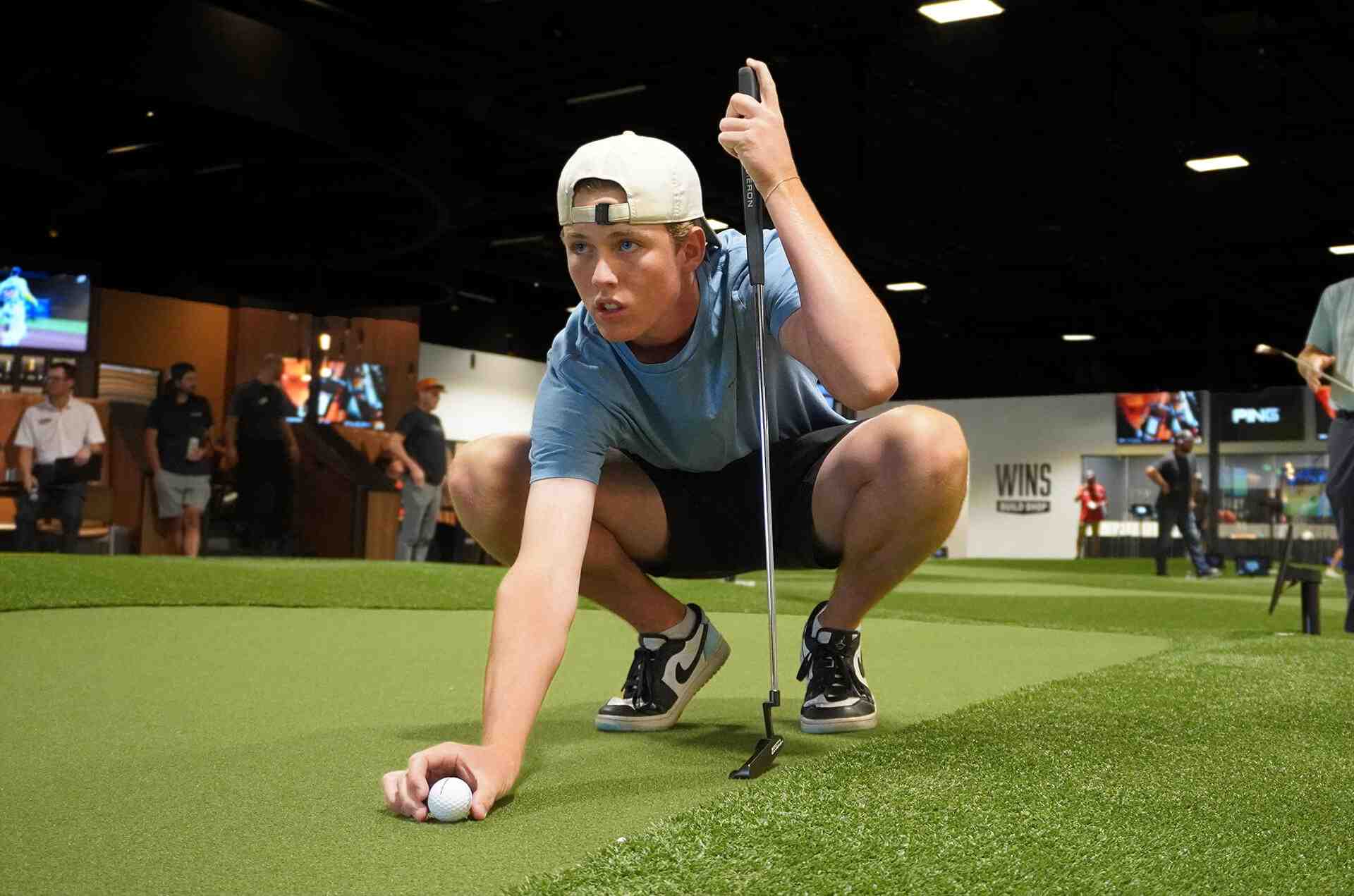 Golfer setting up a putt on the indoor Putting World green