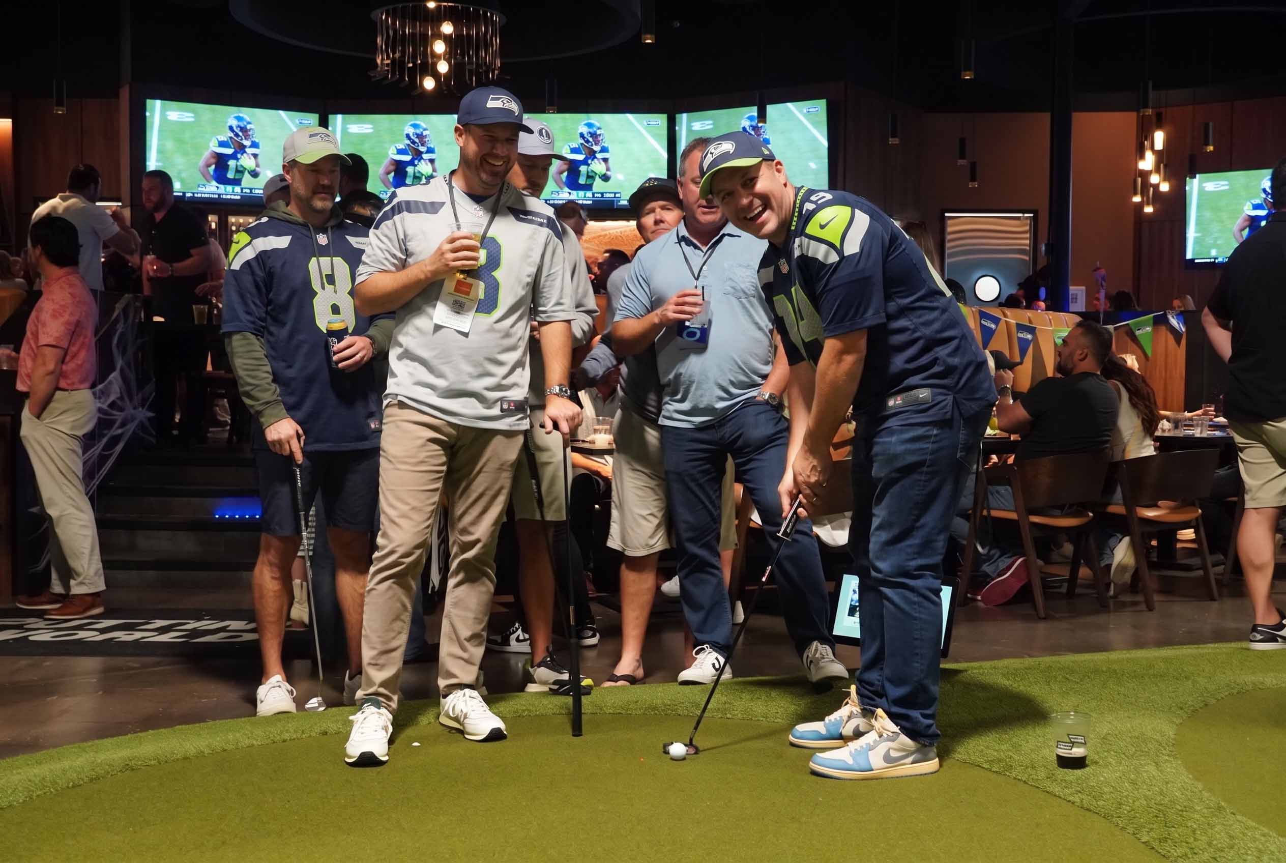 Seattle Seahawks fans putting on an indoor green during a football watch party at Putting World in Scottsdale