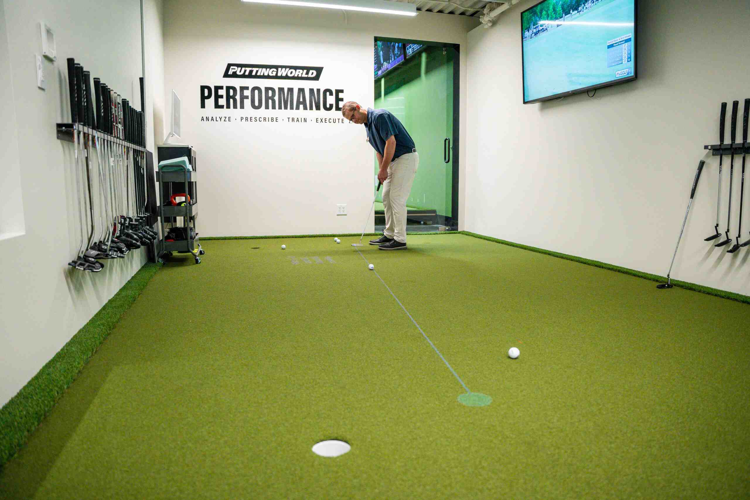 Putting World Performance Studios: a golfer putting on the branded analysis green.