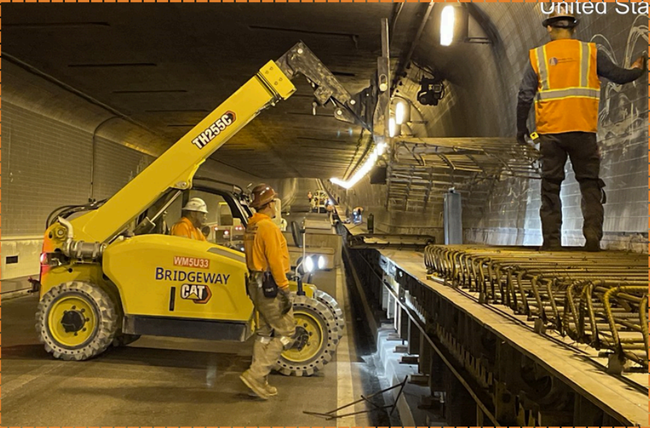 Workers and equipment inside the Webster Tube during construction of the new bike and pedestrian pathway
