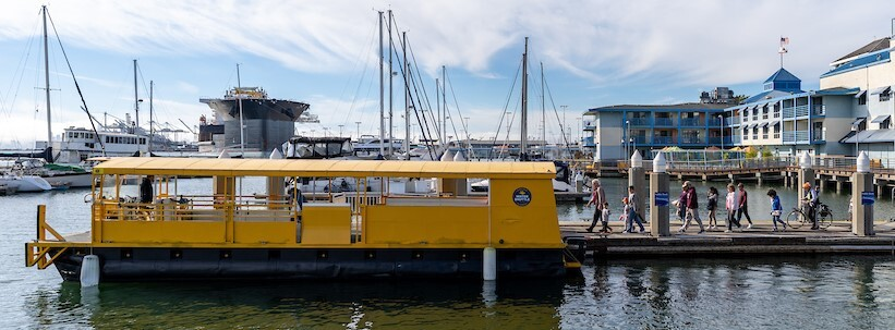 Woodstock water shuttle docked at the marina, with passengers boarding via the pier