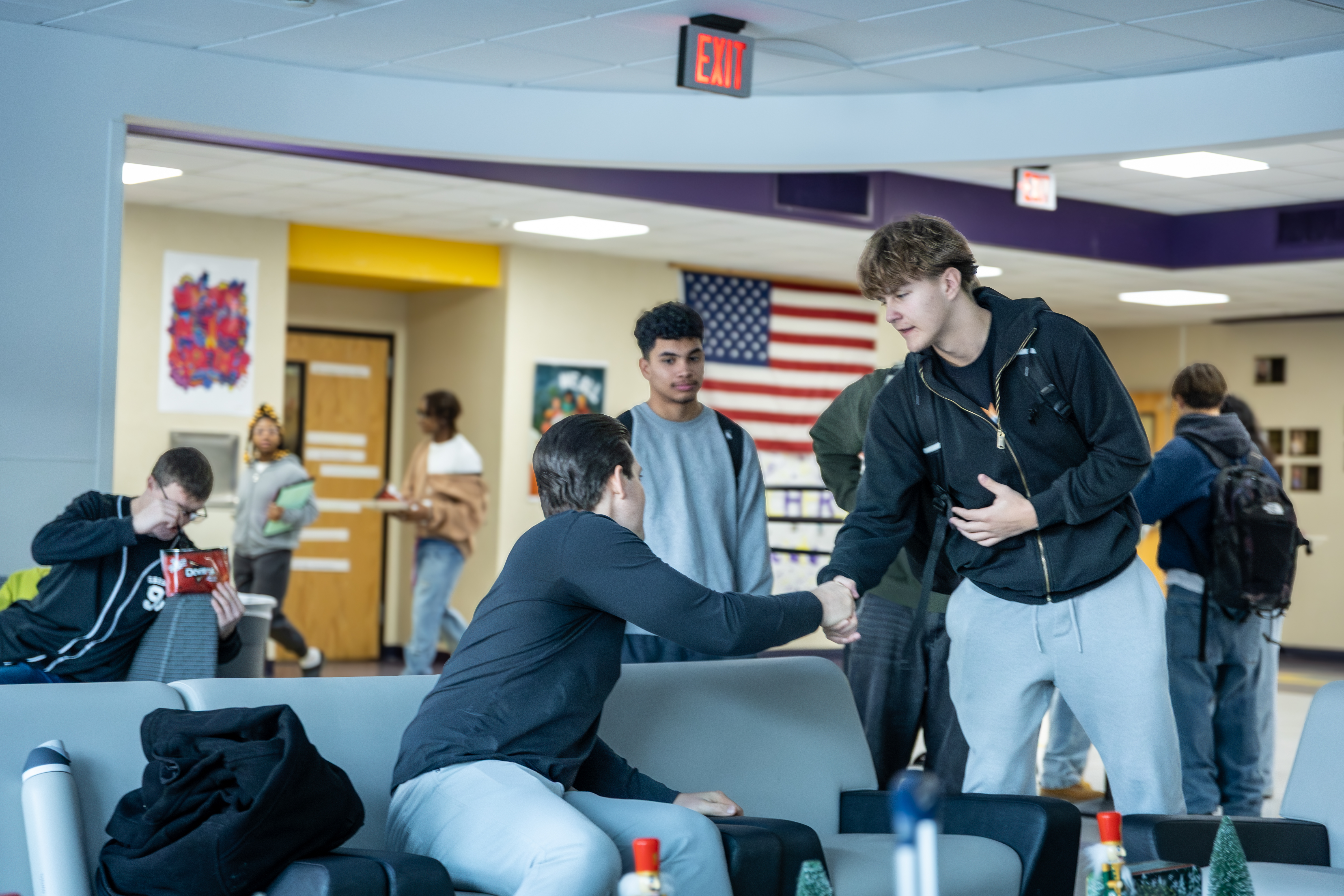 Stephen Hill connecting with students in a school hallway