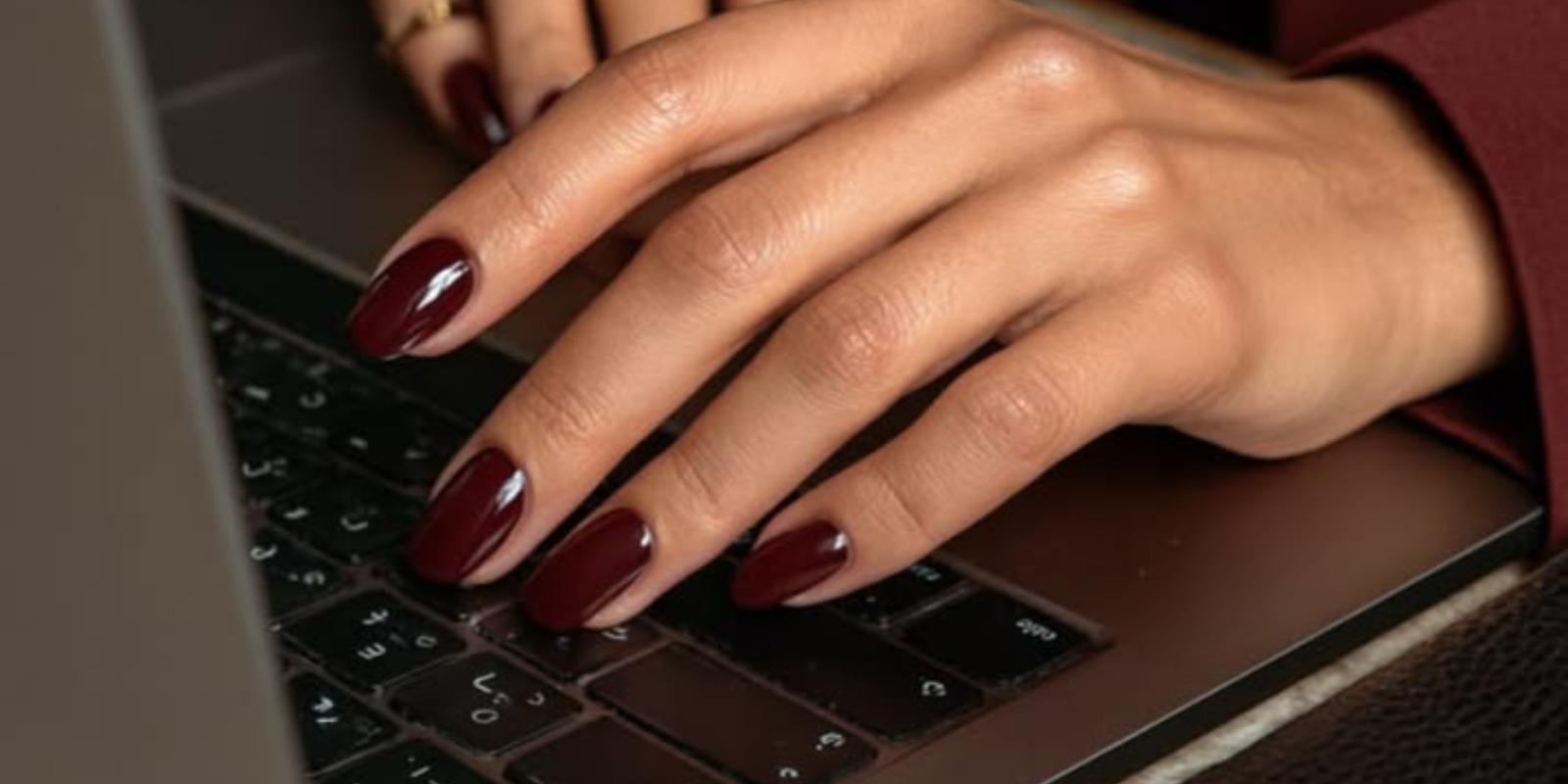 Manicura burdeos sobre el teclado