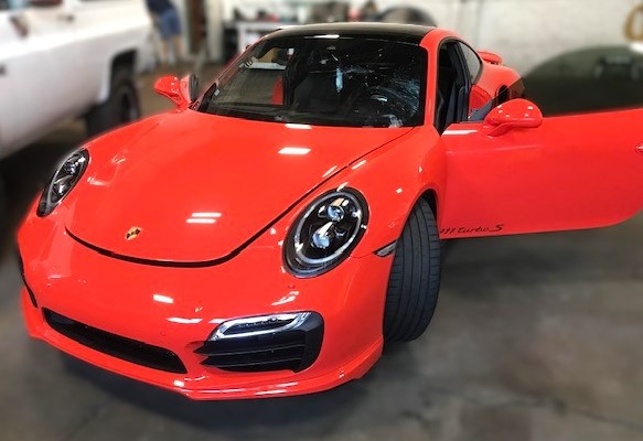 Orange Porsche 911 Turbo S in Capitol Glass shop