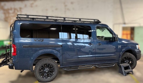 Dark blue Ford F-150 truck with roof rack and off-road tires at Capitol Glass