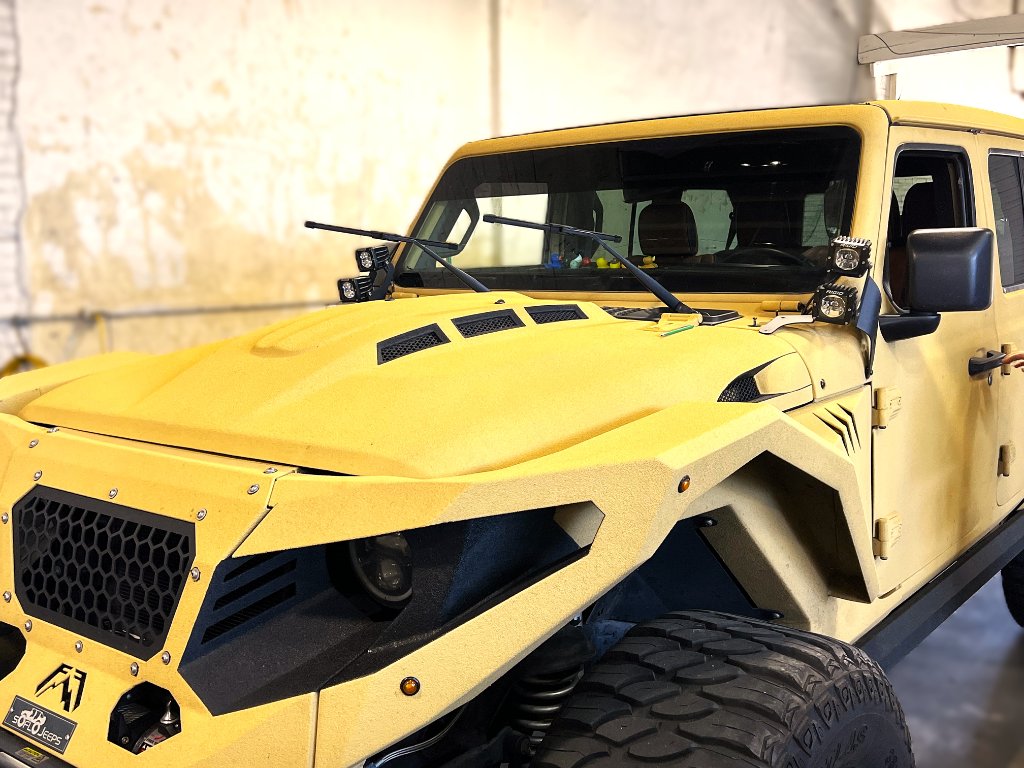 Yellow custom Jeep Wrangler with military-style bodywork at Capitol Glass