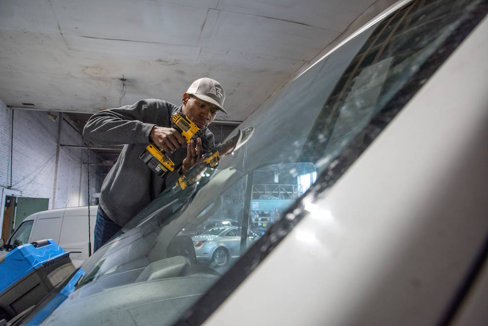 Capitol Glass technician repairing a windshield with a drill