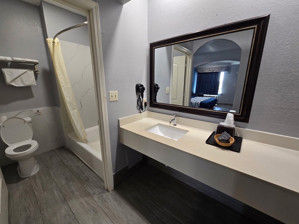 A bathroom with a toilet, shower, and sink