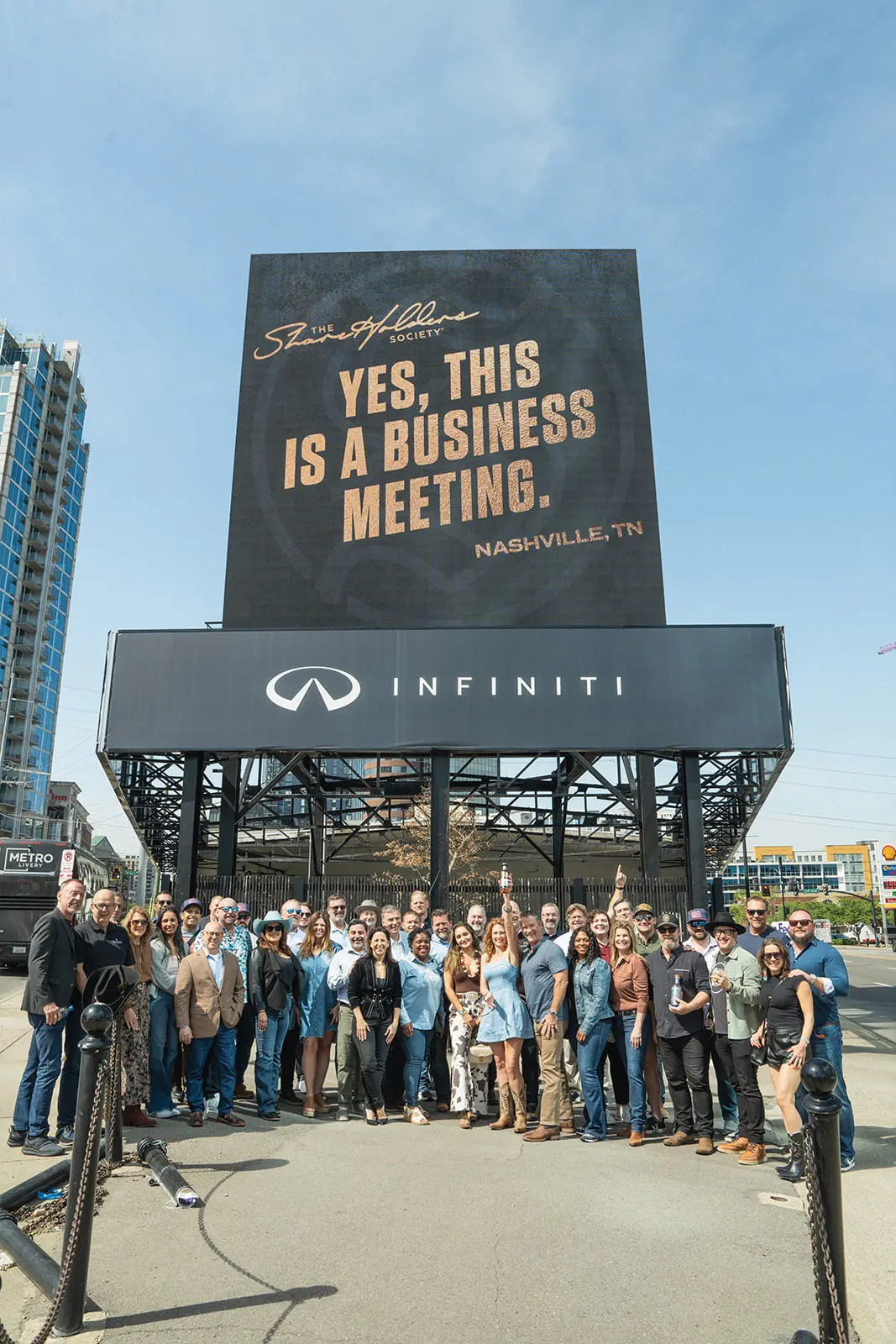 ShareHolders Society members gathered beneath the Yes, This Is a Business Meeting billboard in Nashville