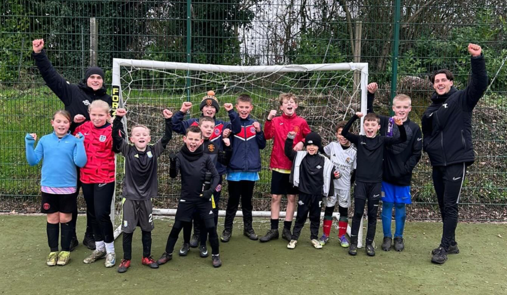 Young people celebrating together at a football session