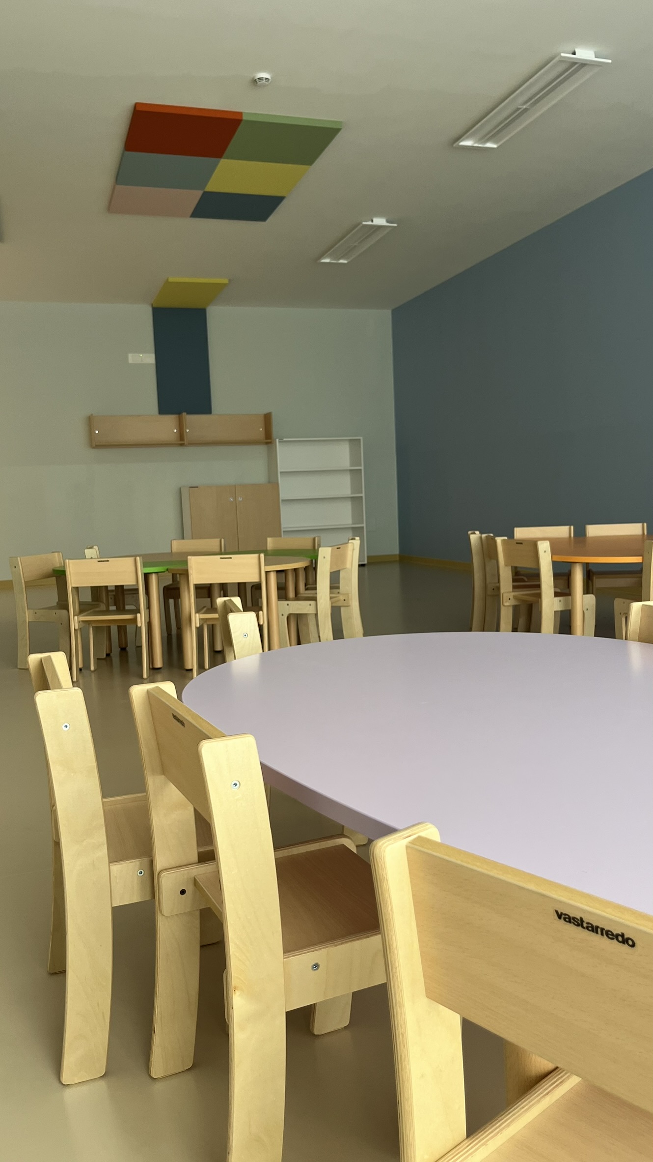 Aula didattica del nuovo Polo dell'Infanzia di San Giovanni Teatino con arredi scolastici in legno installati da PA Opportunity: tavoli circolari, sedute e pannelli acustici colorati