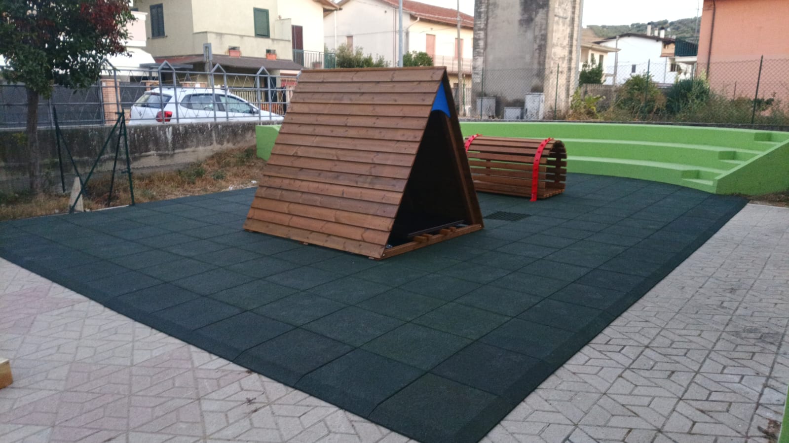Area gioco esterna del nuovo asilo nido di Moscufo con pavimentazione antitrauma verde, giochi in legno e gradonata verde lime