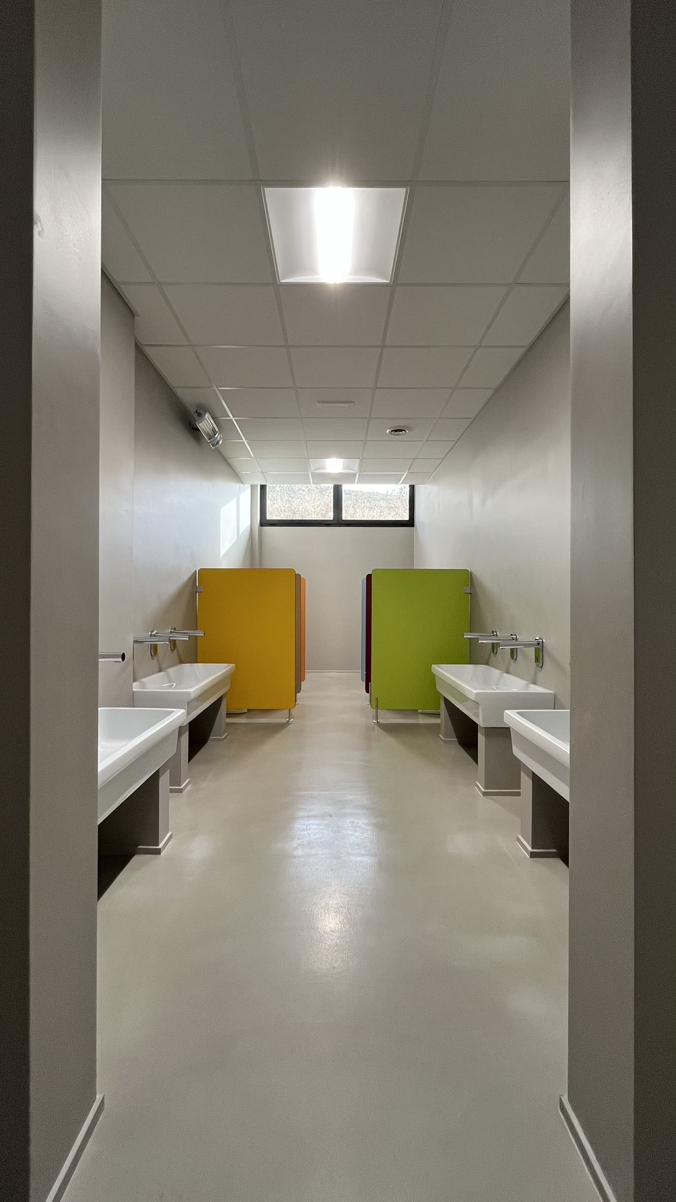 Aula didattica del nuovo Polo dell'Infanzia di San Giovanni Teatino con arredi scolastici in legno installati da PA Opportunity: tavoli circolari, sedute e pannelli acustici colorati