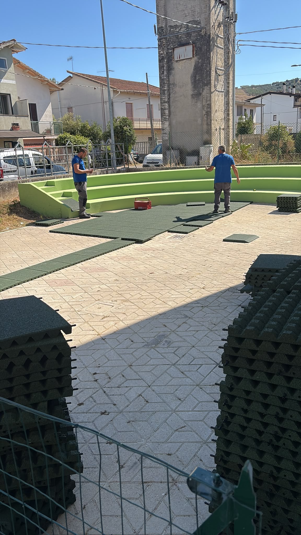 Area gioco esterna del nuovo asilo nido di Moscufo con pavimentazione antitrauma verde, giochi in legno e gradonata verde lime