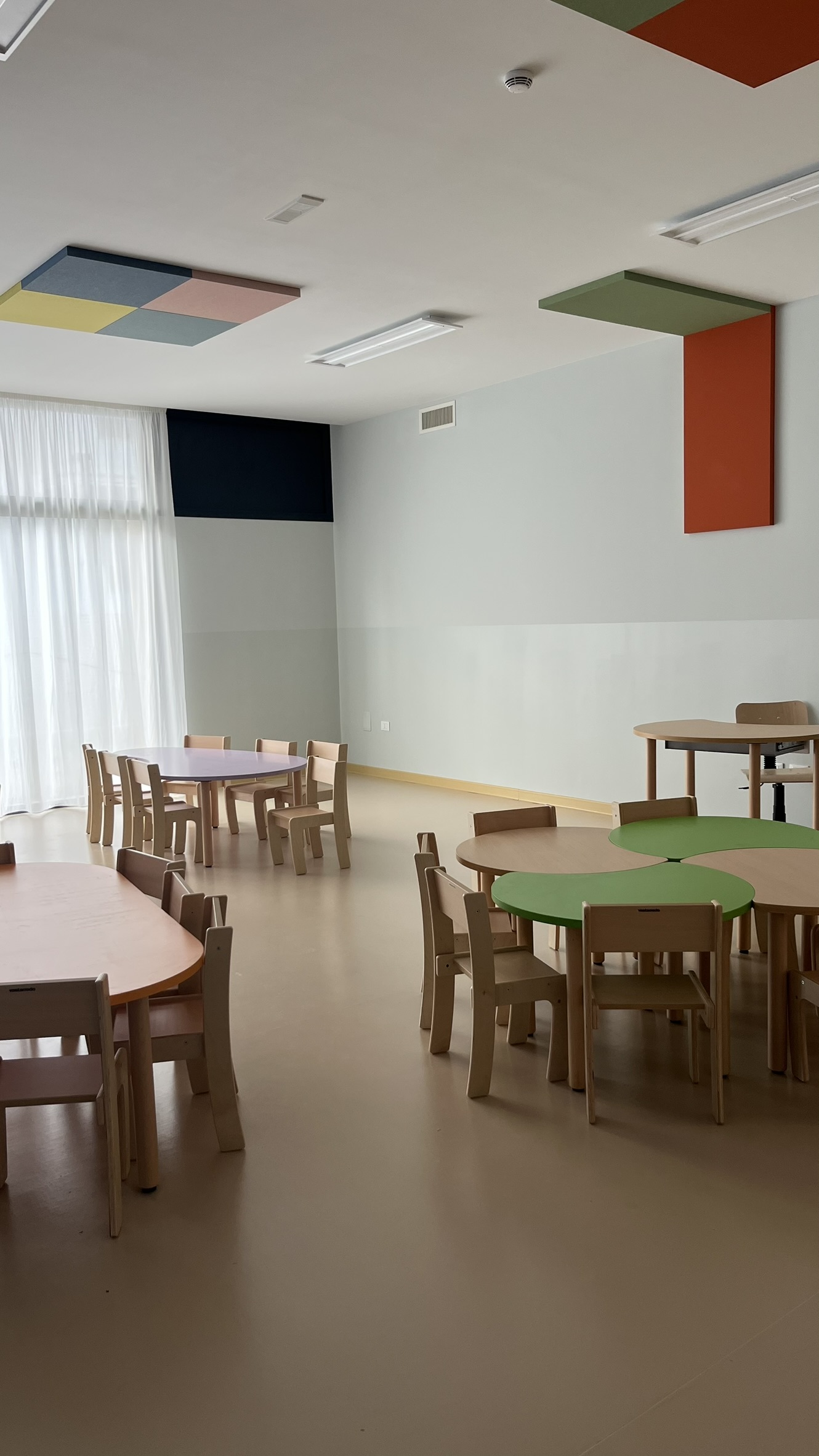 Aula didattica del nuovo Polo dell'Infanzia di San Giovanni Teatino con arredi scolastici in legno installati da PA Opportunity: tavoli circolari, sedute e pannelli acustici colorati
