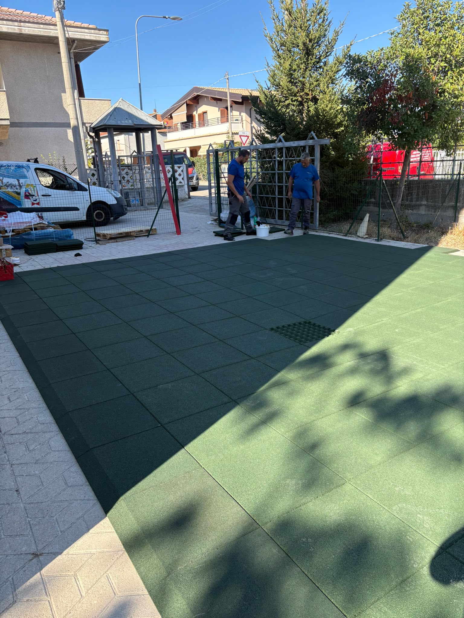 Area gioco esterna del nuovo asilo nido di Moscufo con pavimentazione antitrauma verde, giochi in legno e gradonata verde lime