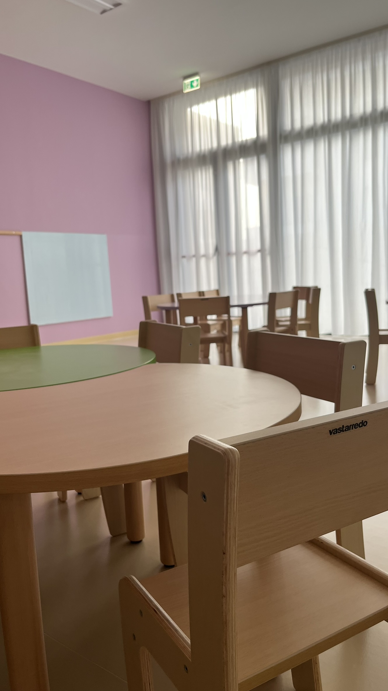 Aula didattica del nuovo Polo dell'Infanzia di San Giovanni Teatino con arredi scolastici in legno installati da PA Opportunity: tavoli circolari, sedute e pannelli acustici colorati