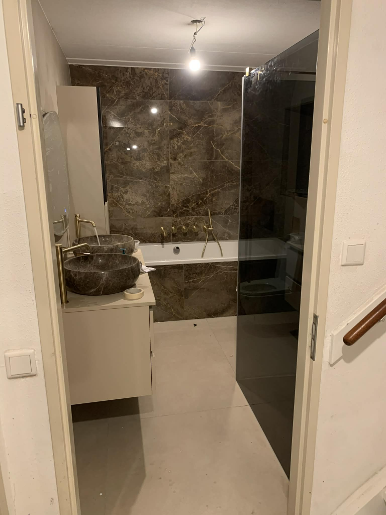 Badkamer met marmer tegels en bad