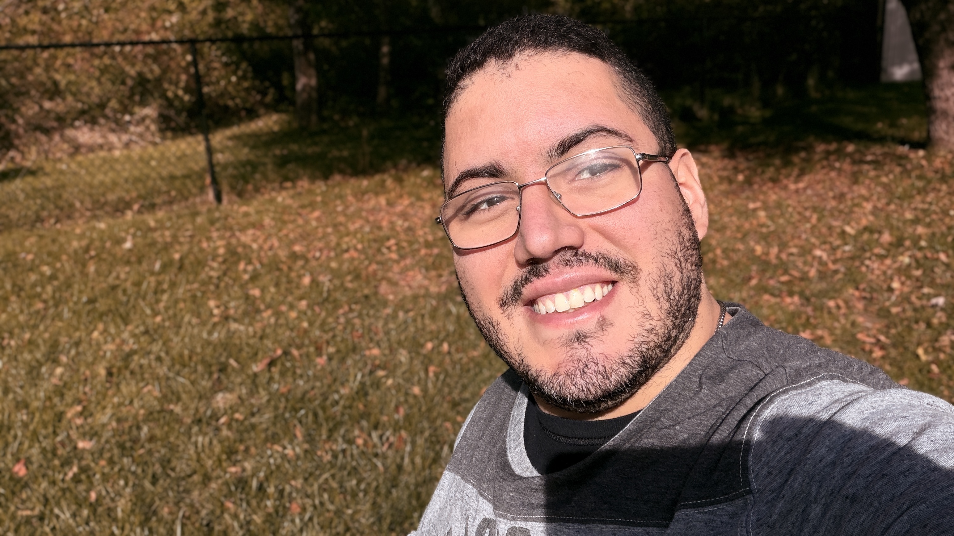 Close-up self-portrait in golden-hour light against a fall garden