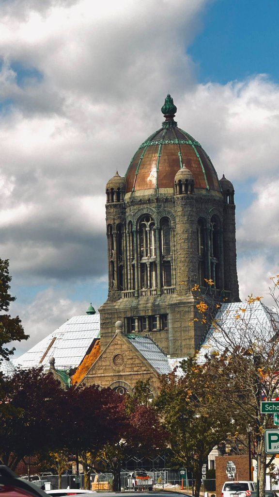 Historic stone church tower against dramatic cloudy sky