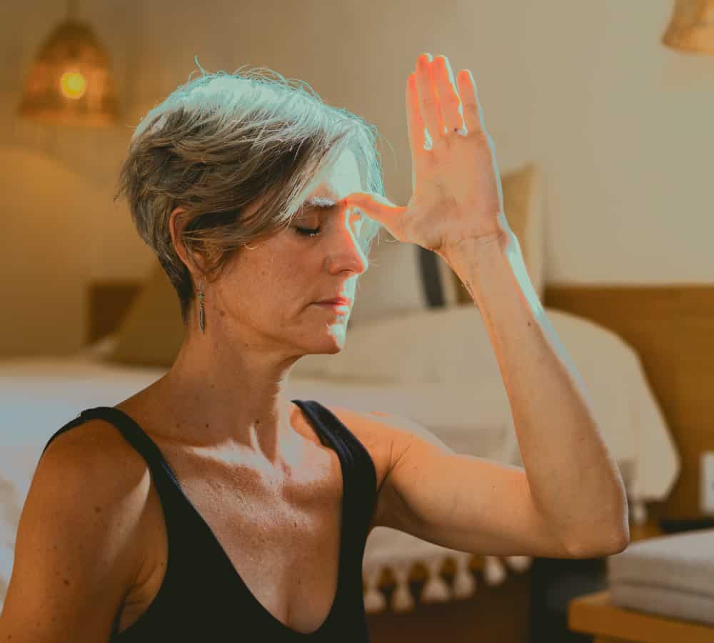 Woman with hand to her forehead