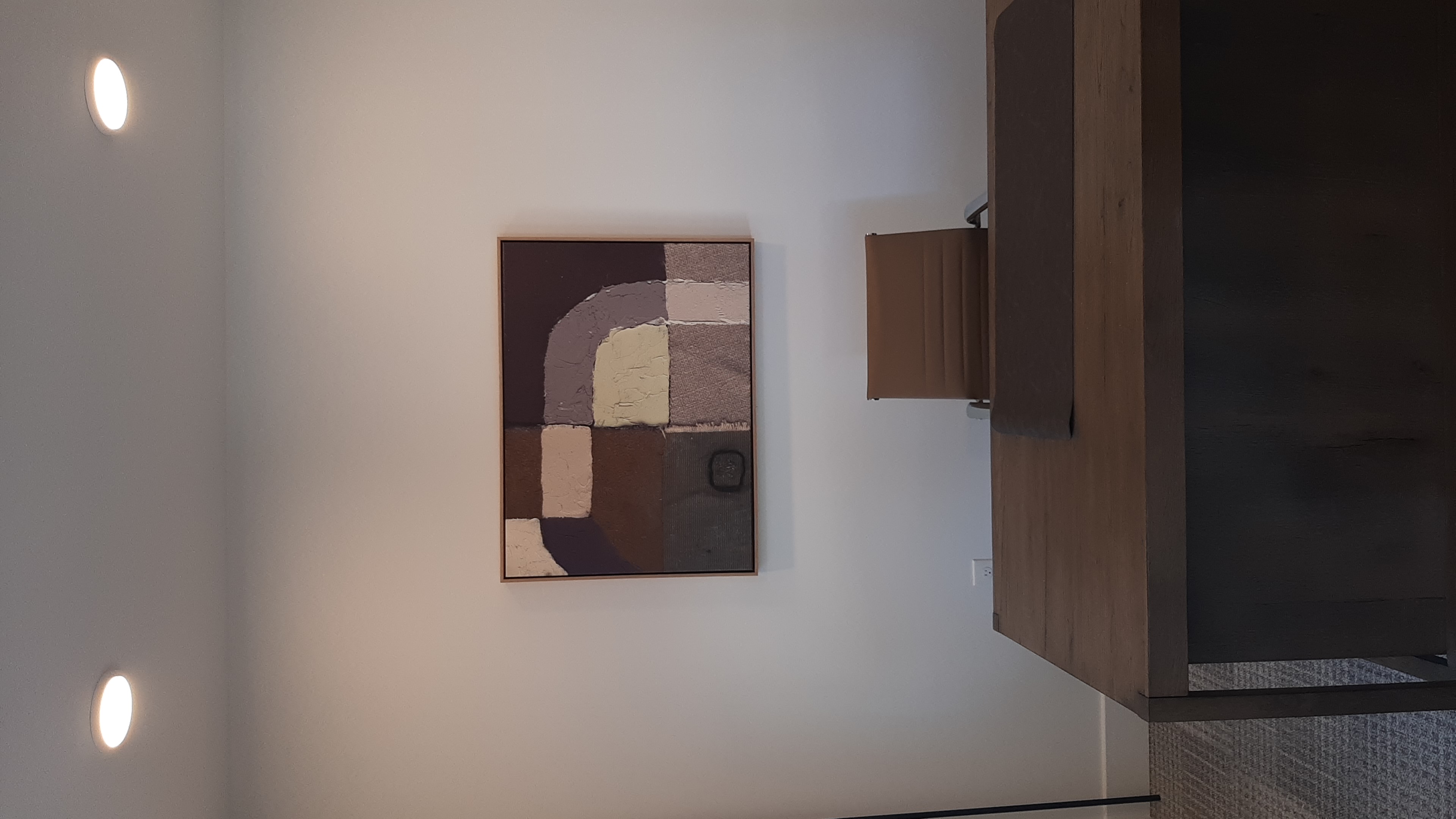 Framed abstract canvas mounted above a leasing office desk in Edmond, OK