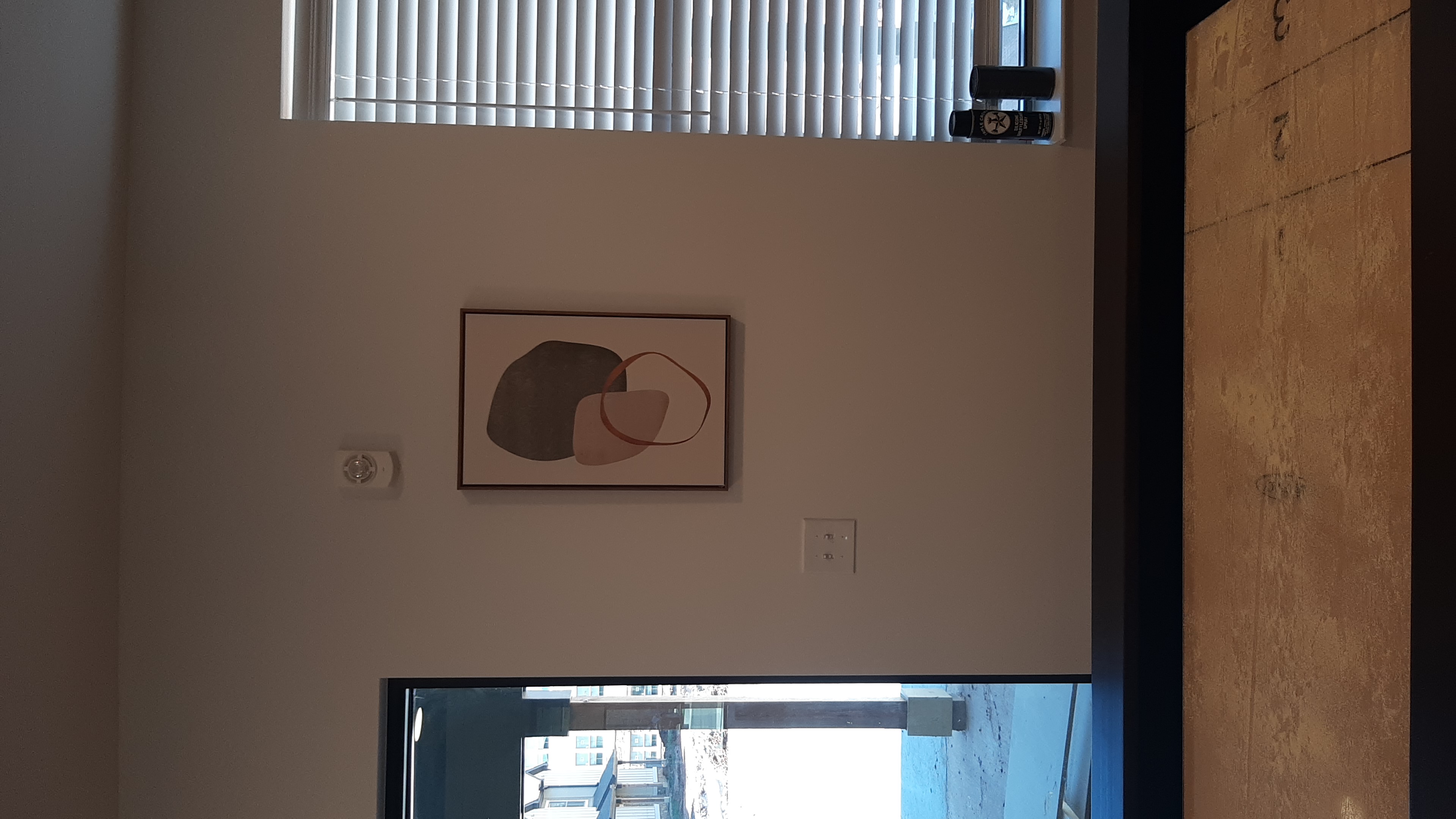 Lounge Abstract Art Mounting in Edmond, OK | Redhawk Handyman Small framed abstract art mounted beside a window in a resident lounge at a new Edmond, OK apartment community