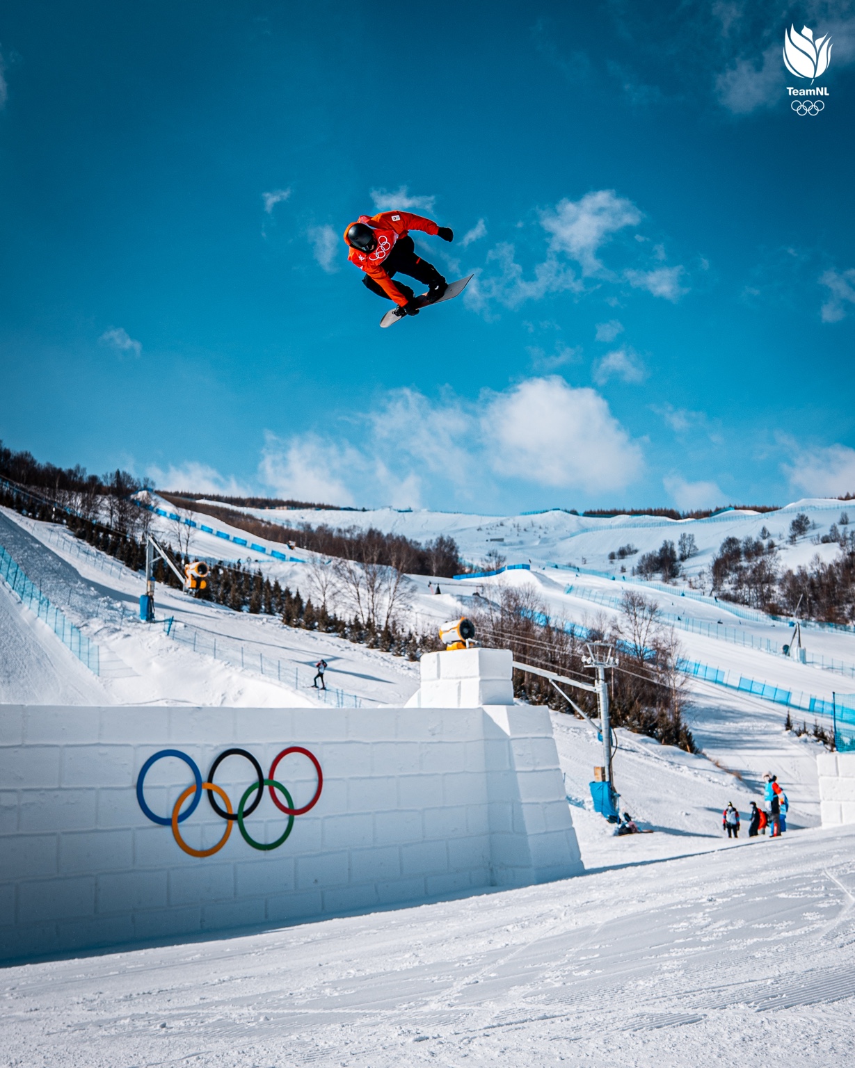 Snowboarder hoog in de lucht boven het Olympische parcours