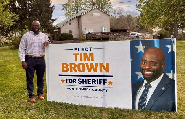 Tim Brown putting up a campaign sign in the community