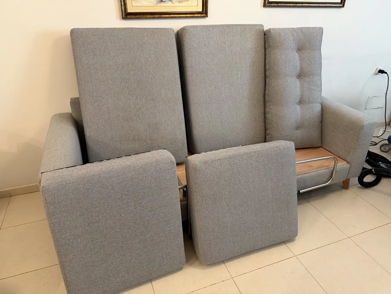 ספה אפורה בהירה עם כריות מנותקות במהלך ניקוי